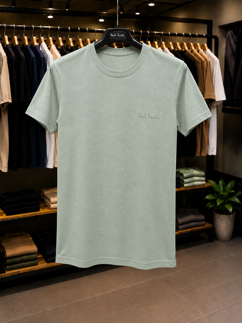 A light sage green t-shirt with 'Paul Smith' in 100% Cotton.