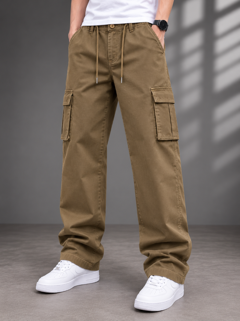 A person wearing loose-fit olive brown cargo pants with side flap pockets, a drawstring waist, and white sneakers, 