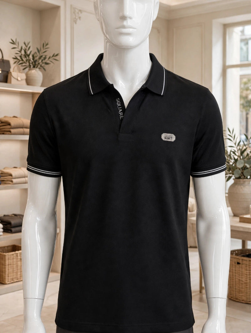 A black short-sleeve polo shirt with white contrast stitching on the collar and sleeve cuffs, displayed on a white mannequin torso inside a softly lit boutique interior.