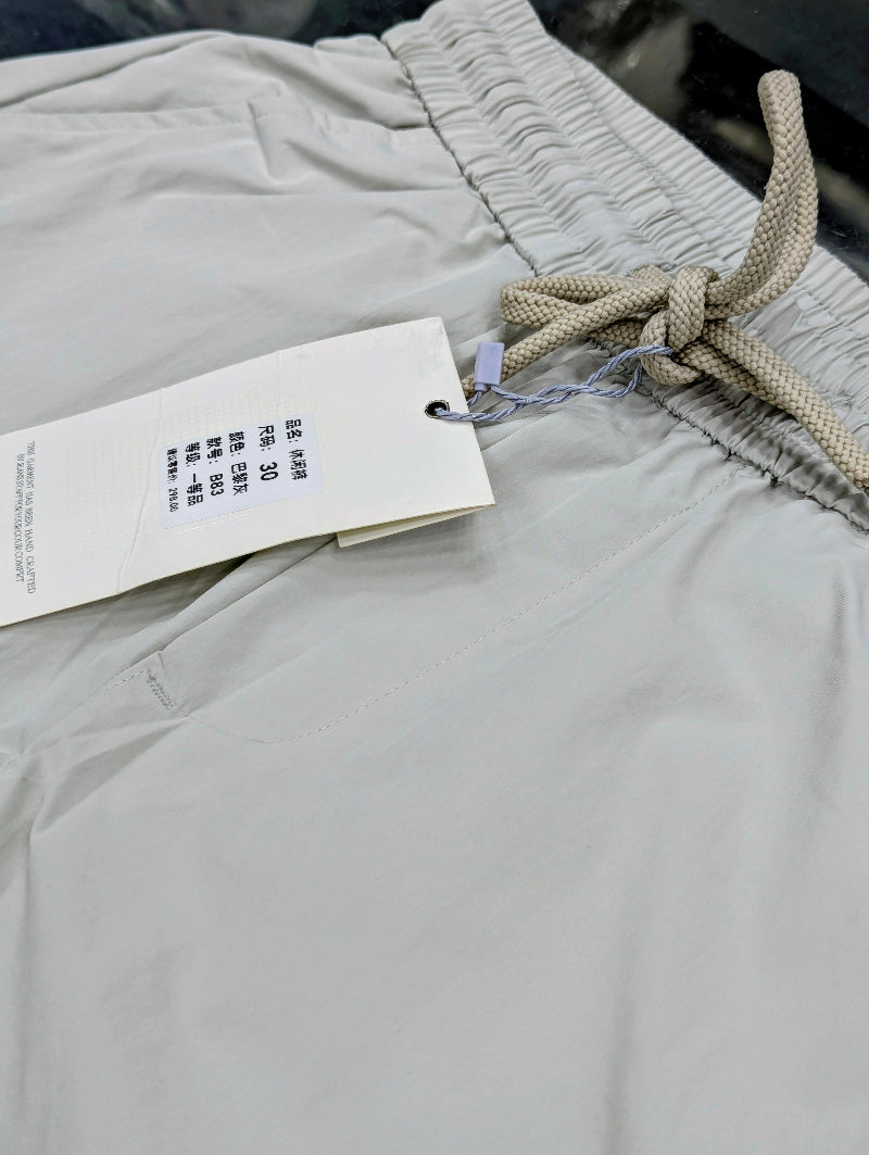 Close-up of off White Baggy Trouser with an elastic waistband and a white size tag attached near the drawstring.