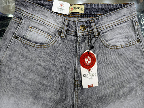 Close-up of Baggy Jeans RiverSide denim jeans in a washed light gray wash, showing the waistband, front pockets, button, and hanging red and white brand tags.