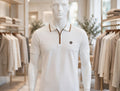 A white short-sleeve polo shirt with a brown zipper collar and a small embroidered logo on the chest.